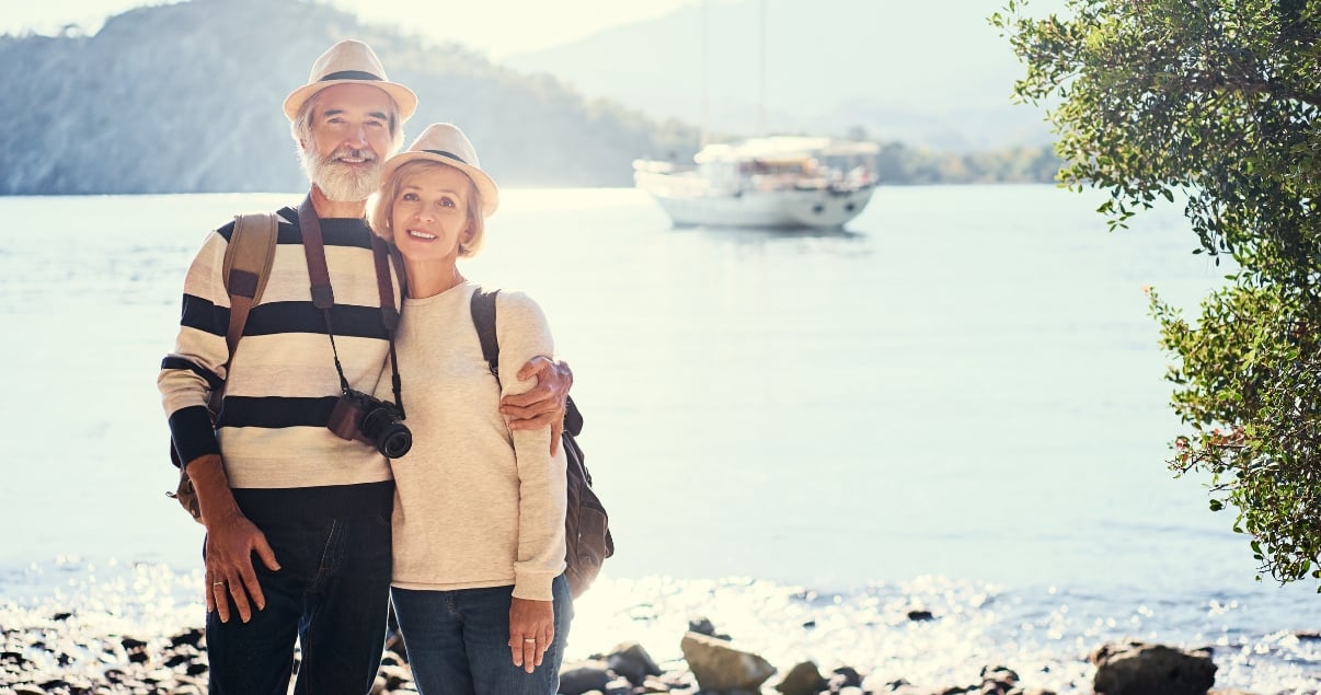 middle-aged-couple-smiley-with-hats-at-beach.jpg