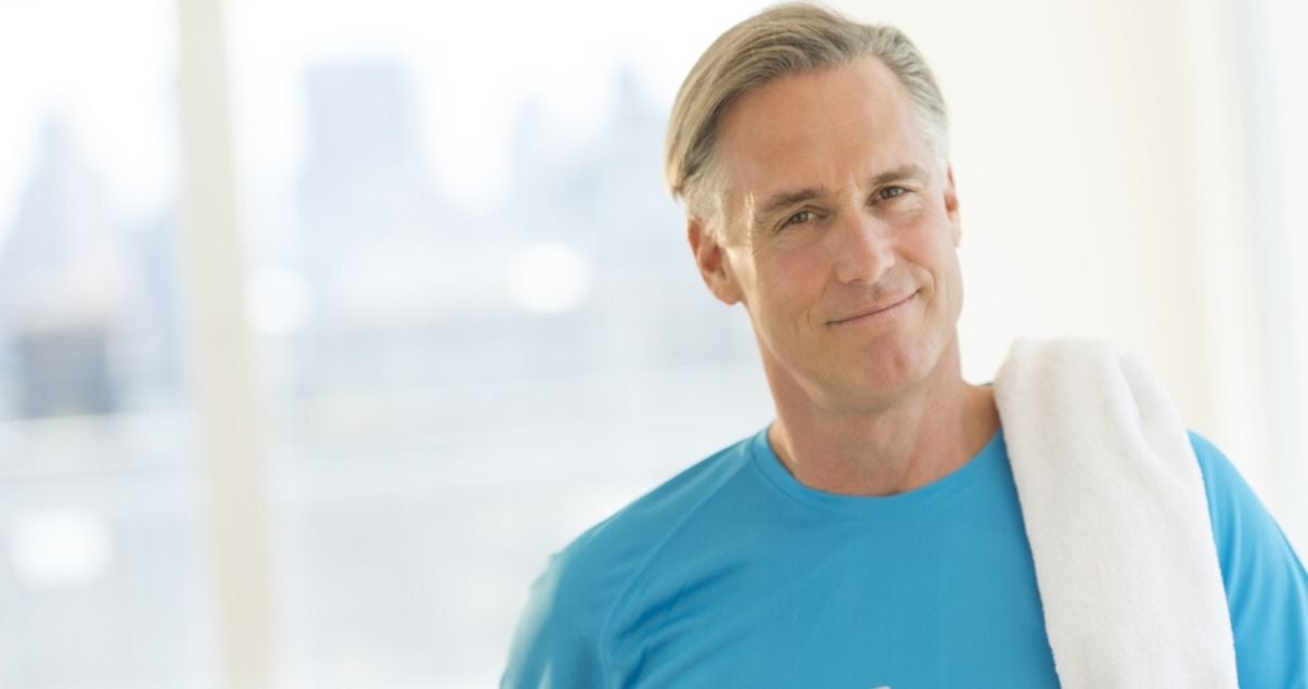 mature man working out with hair system in blue shirt