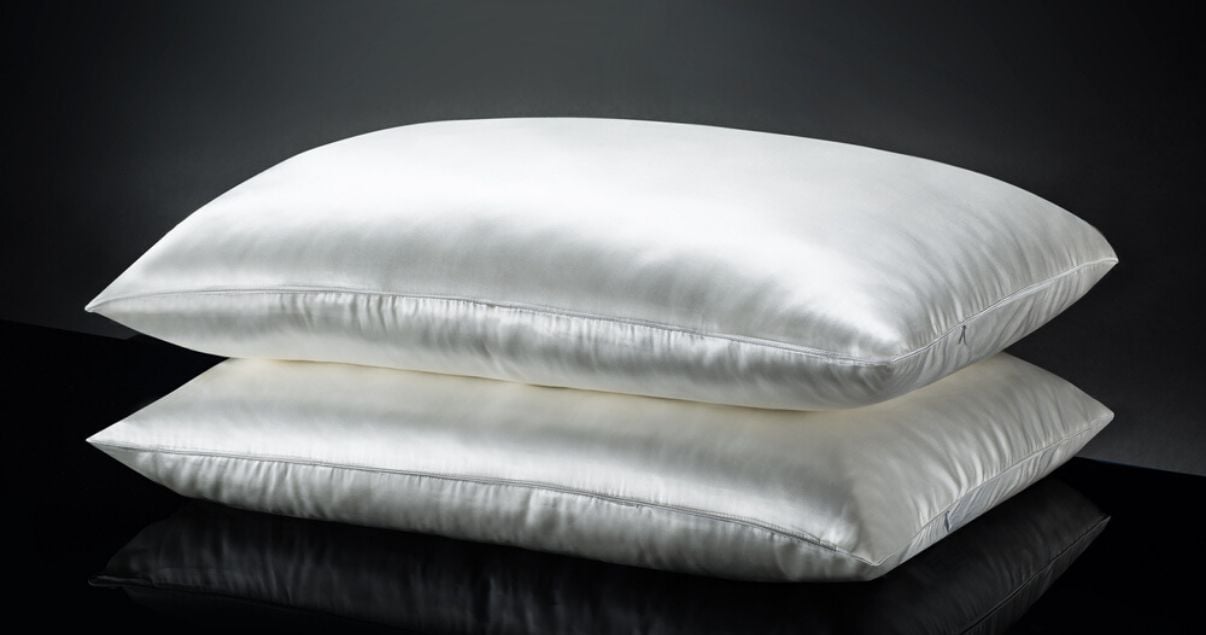 white silk pillows against black background good for sleeping in hairpiece