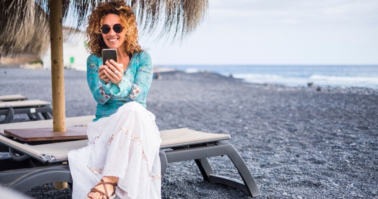 happy woman on vacation traveling with a hairpiece enjoying tropical beach