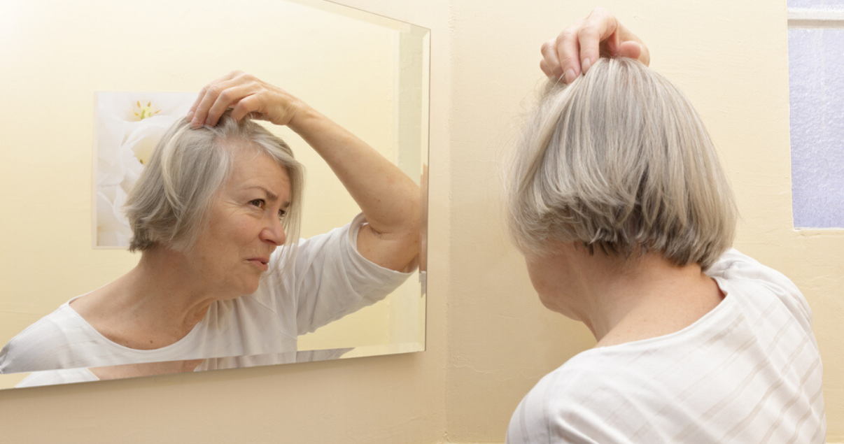 mature woman following scalp maintenance advice by massaging scalp and applying soothing oil