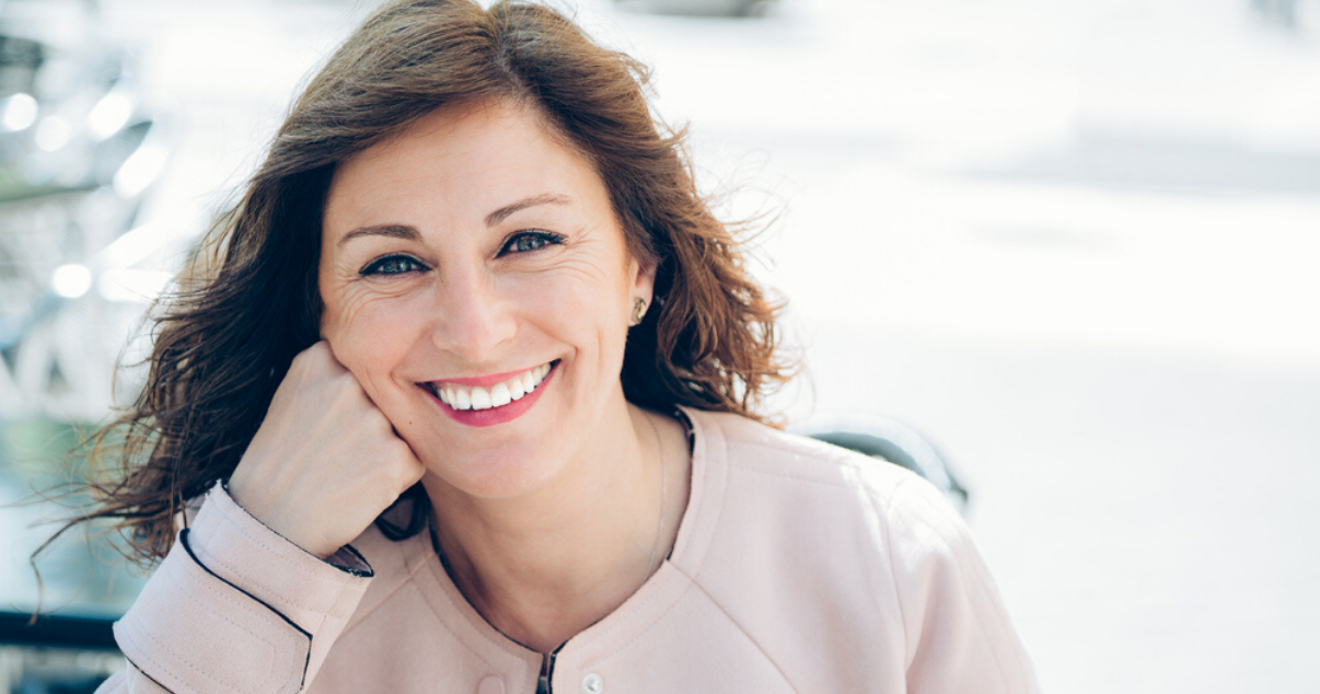 middle aged woman enjoying her soft hair system after moisturizing it with leave in conditioner