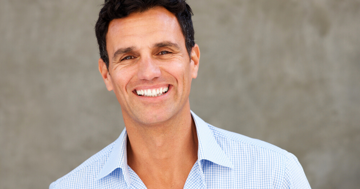 Smiling mature man wearing hair system maintained with proper hairpiece care (1)