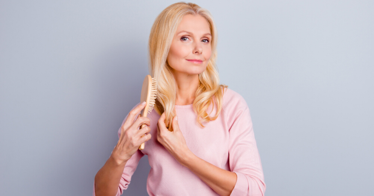 Mature woman improving hair system lifespan by maintaining it