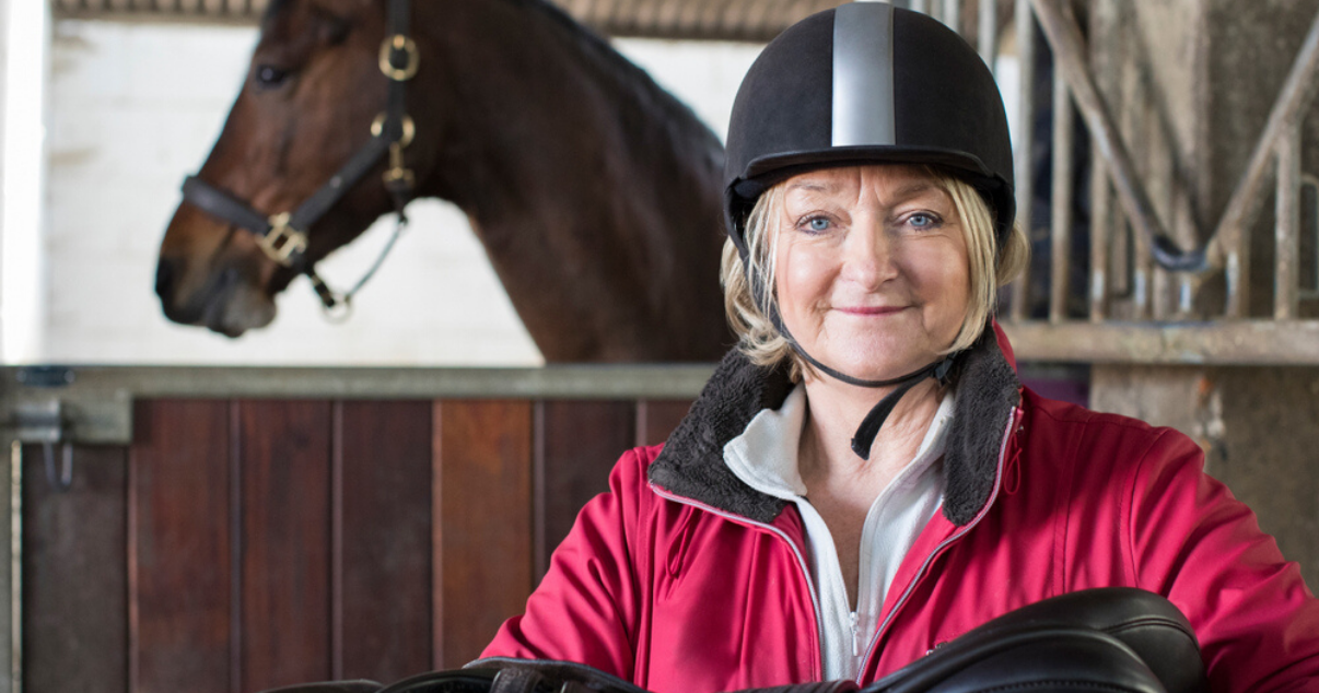 Happy woman wearing high quality hair system while horse back riding