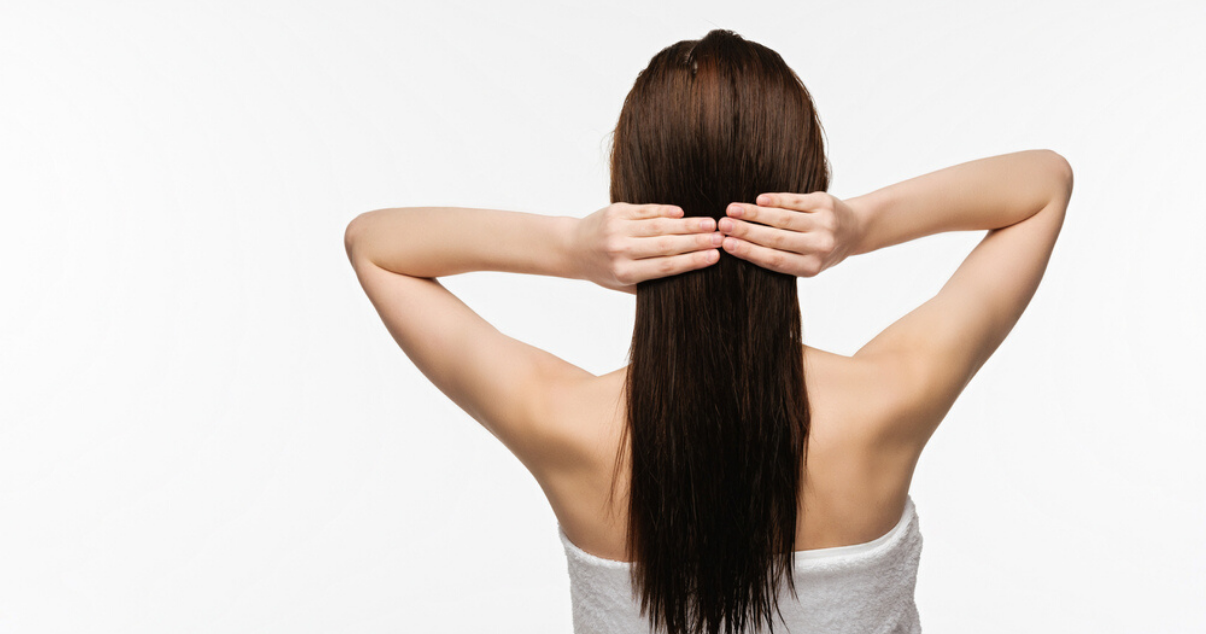 Middle aged woman performing at home hair system application