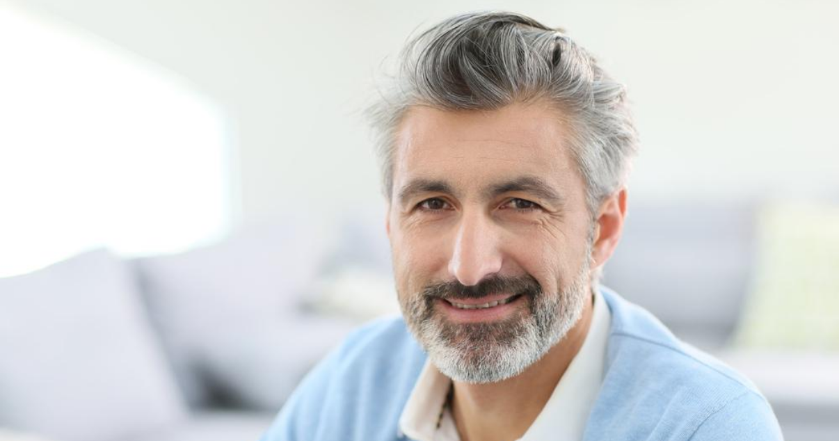 Mature man successfully using glue on toupee hairpiece