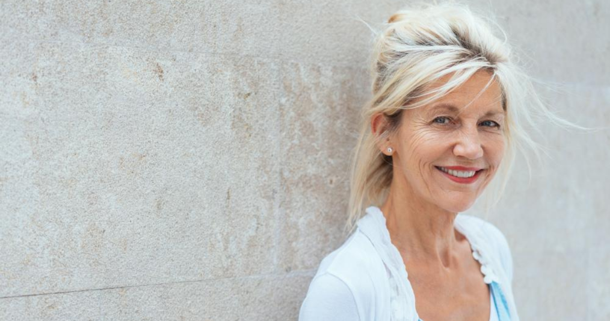 Mature woman standing in sunlight with great hair system maintenance routine