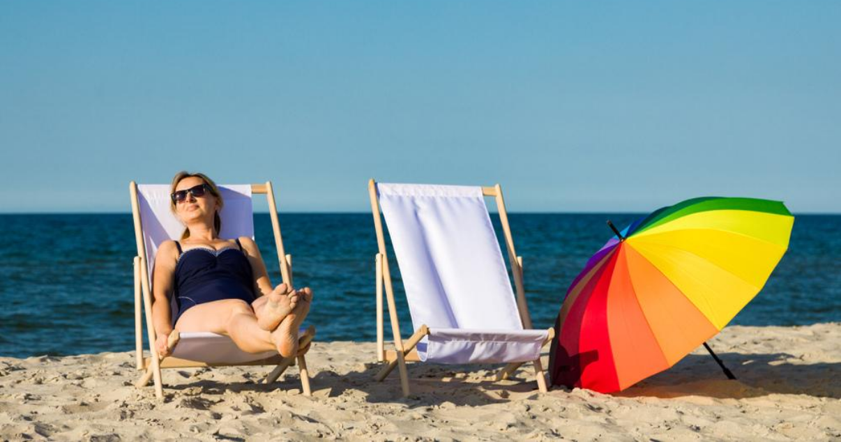 Middle aged woman relaxing on beach with good hair system maintenance