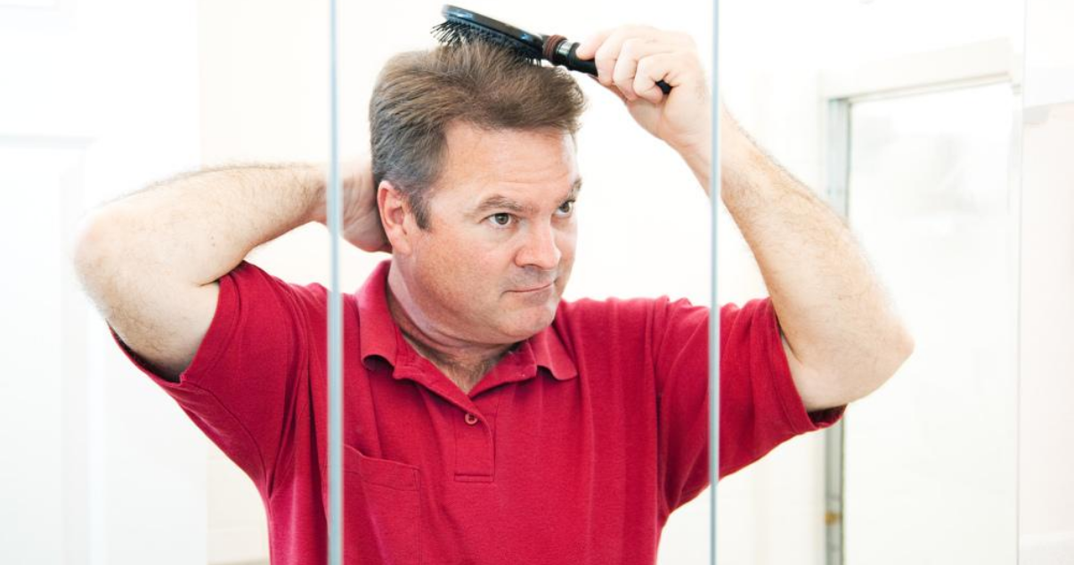 Mature man doing hair system maintenance at home without a hair club