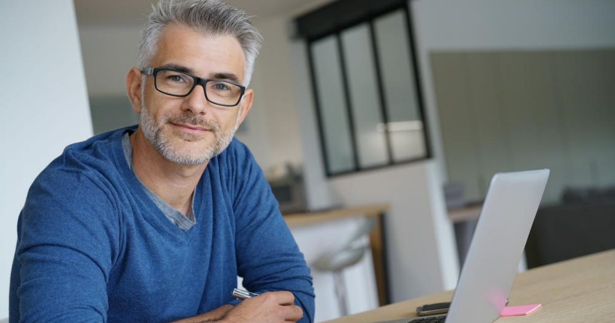 Middle aged man working from home using hair systems for men