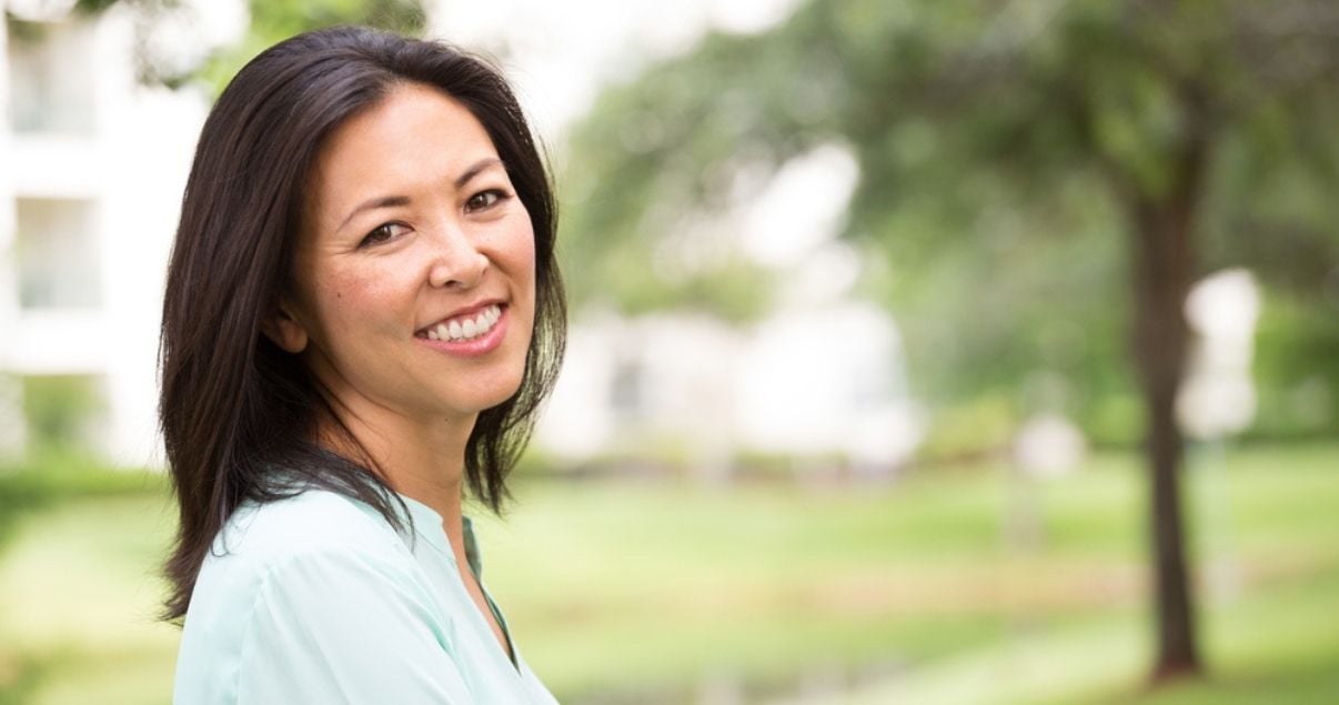 Portrait of happy middle aged woman outside wearing womens wig