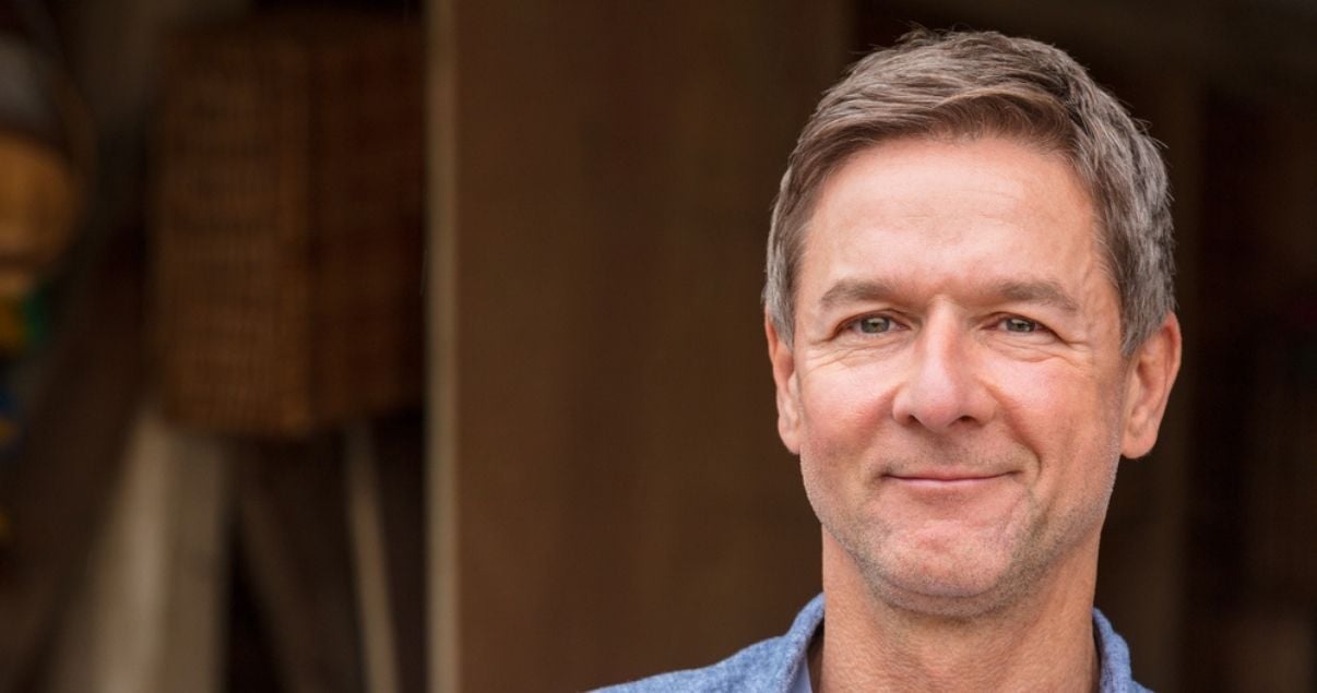 Smiling middle aged man wearing hairpiece for men