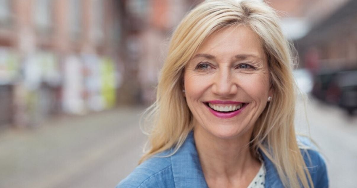 mature woman happy with her hair system after removing hairpiece adhesive buildup