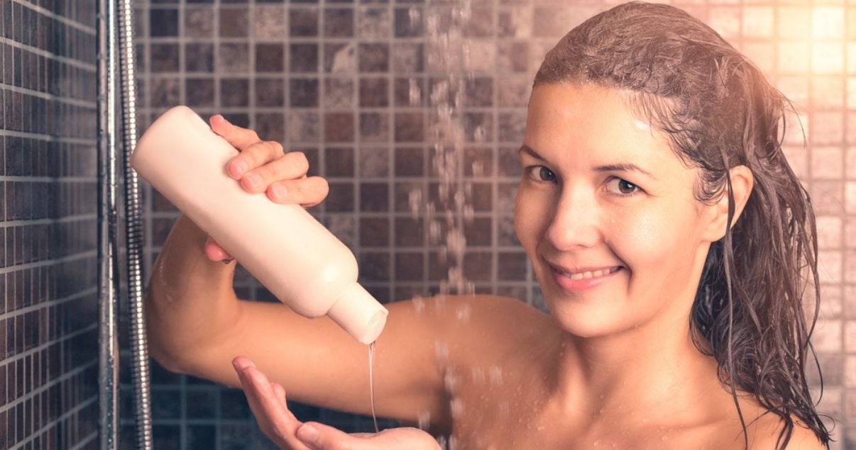 Middle aged brunette woman using shampoo for wigs