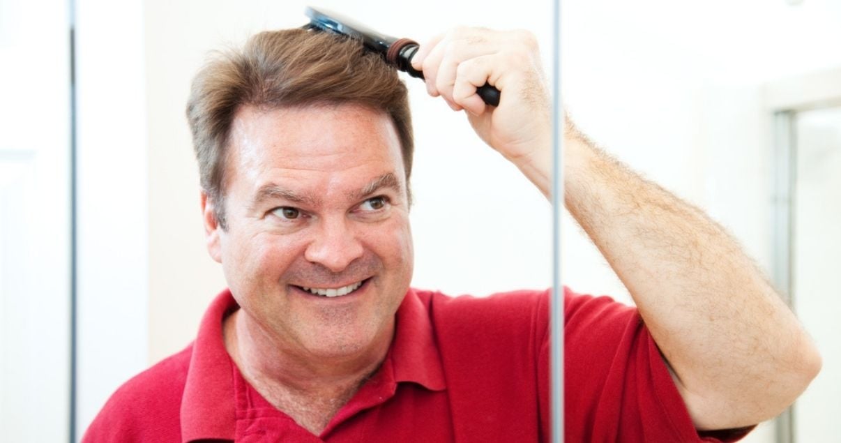 Middle aged man brushing his hair system