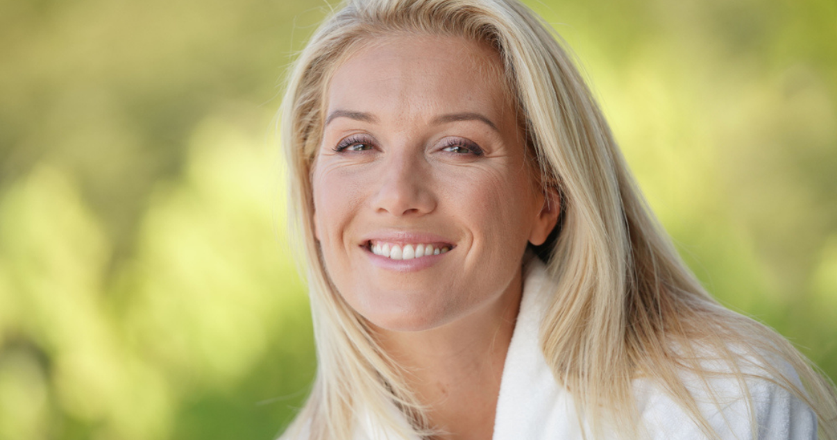 Blonde middle aged woman wearing a hair system