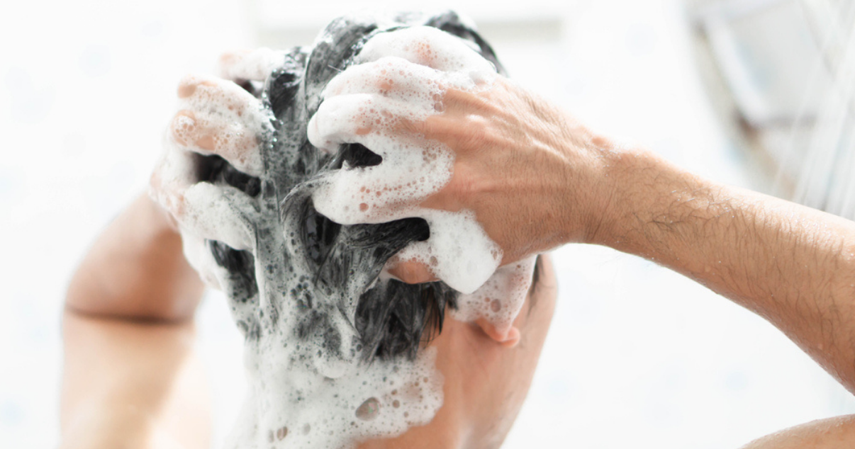 Man showering and taking care of his damaged scalp