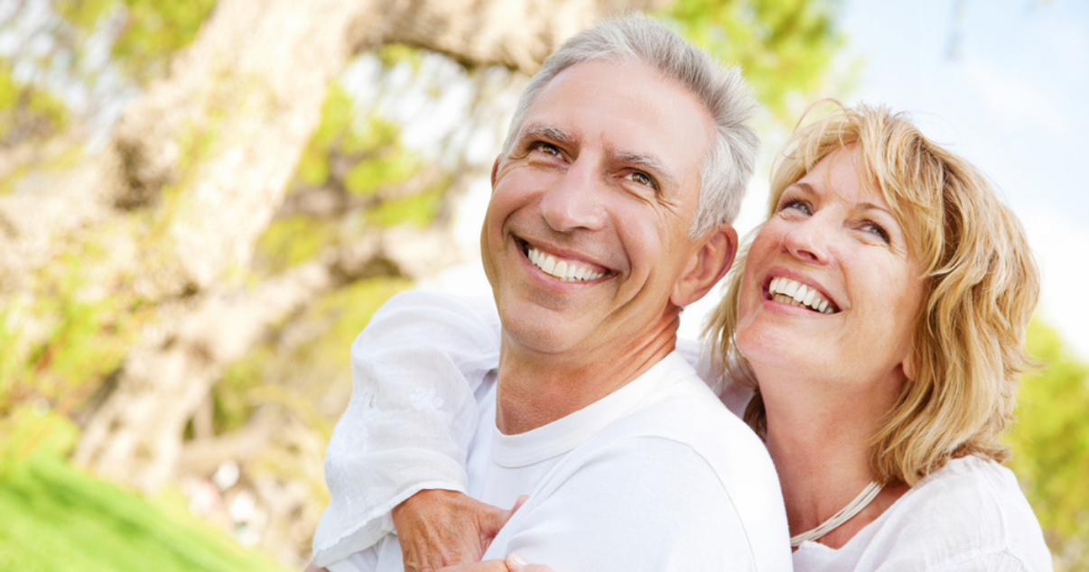 Middle age couple enjoying outside thanks that he is using a bio matrix hairpiece 