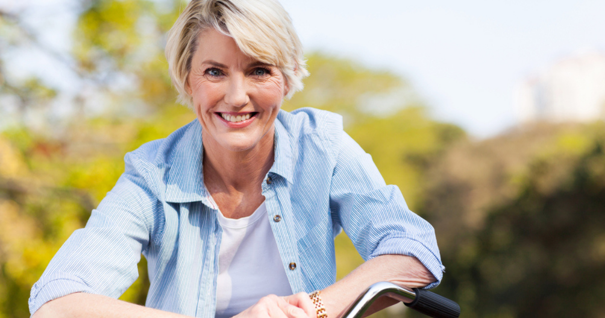 Middle age woman riding a bike with her custom hair system