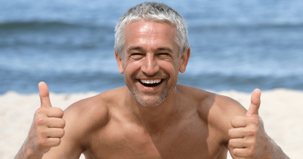 Middle aged man at the beach with his hairpieces