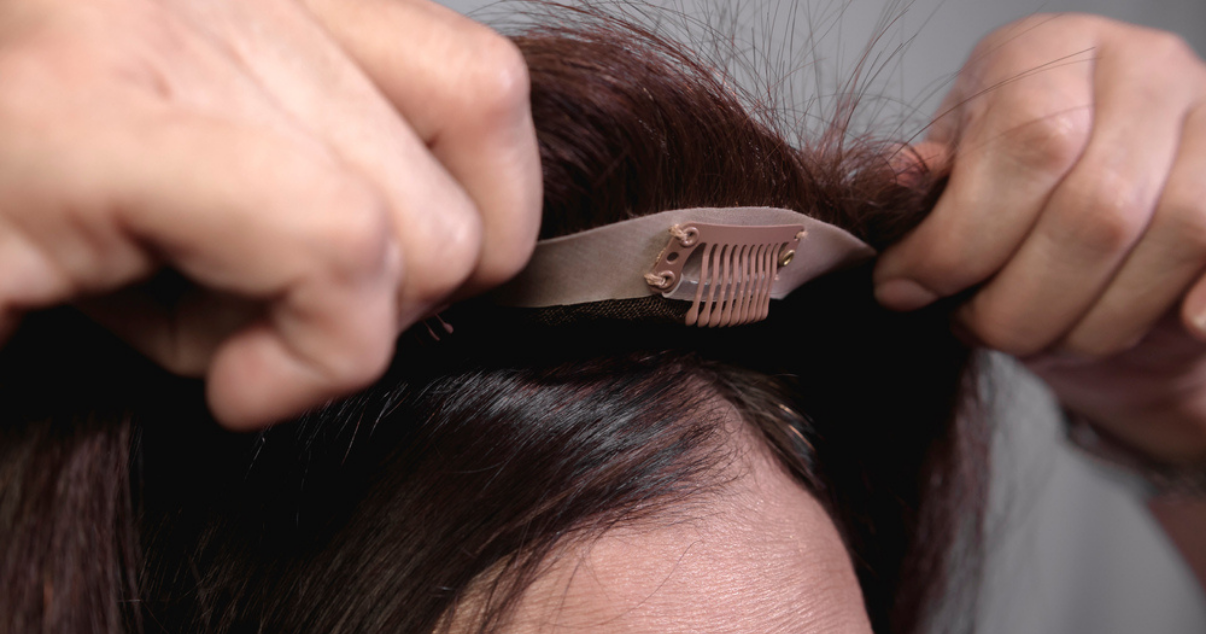 Woman applying her new hairpiece