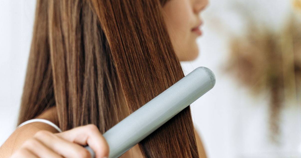 Woman straightening her hair extensions