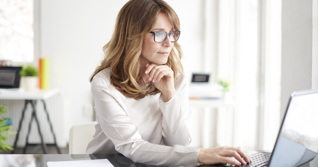Woman wearing glasses and looking at Advent Hair website