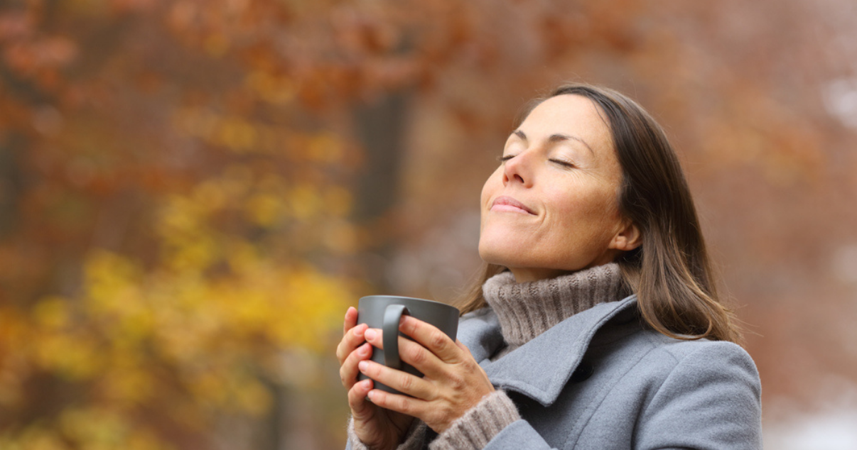 Young woman enjoying a coffee outside while wearing her hair system