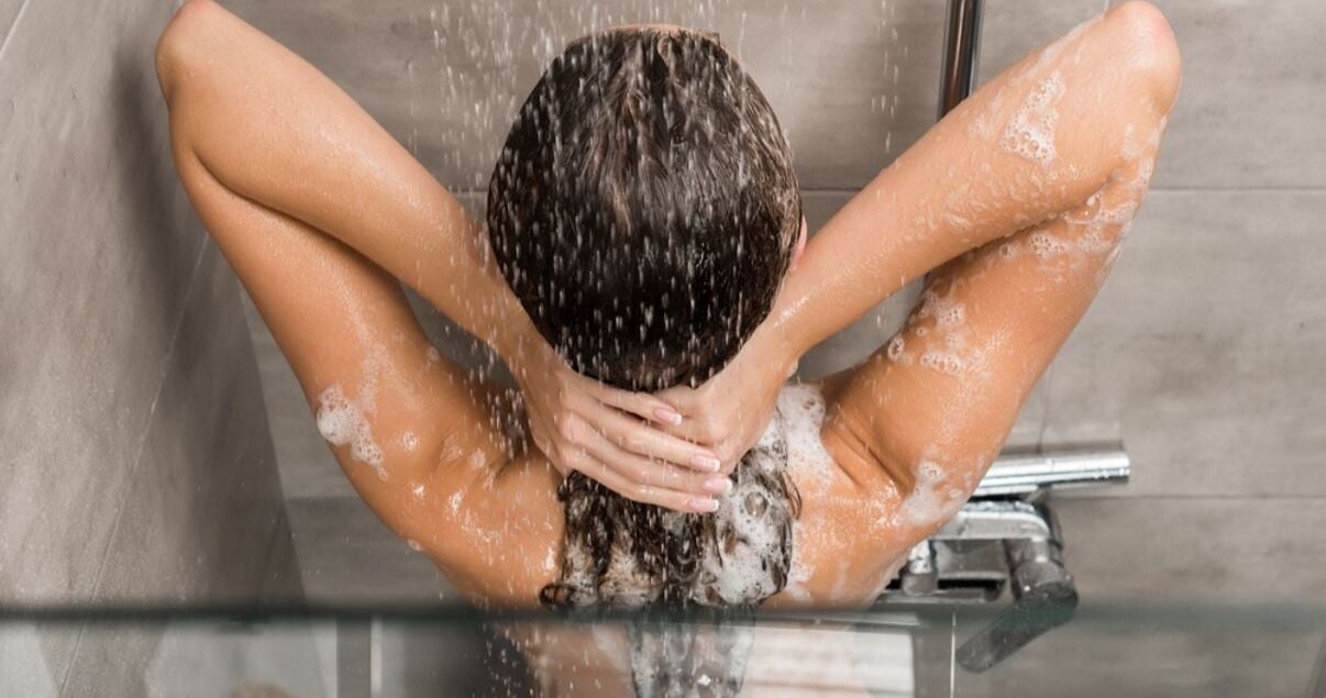 mature woman washing hair system in the shower 