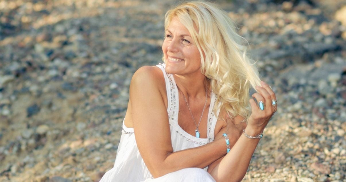 middle aged woman enjoying beach day with healthy hairpiece made with strong hair knots