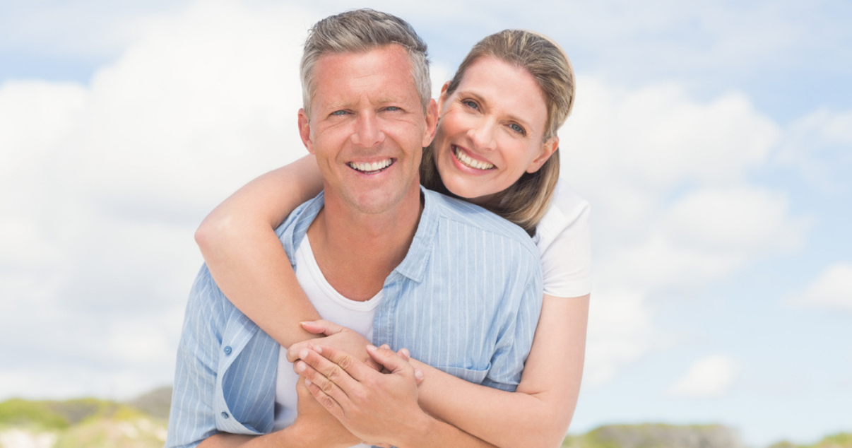 Couple enjoying the beach without worrying about hair damage from the sun 