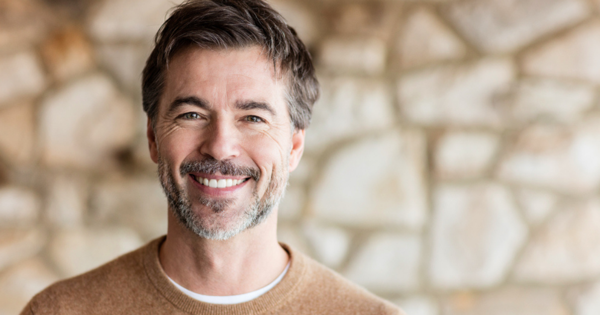 Middle age man happy with his choice to use hairpieces for men. 